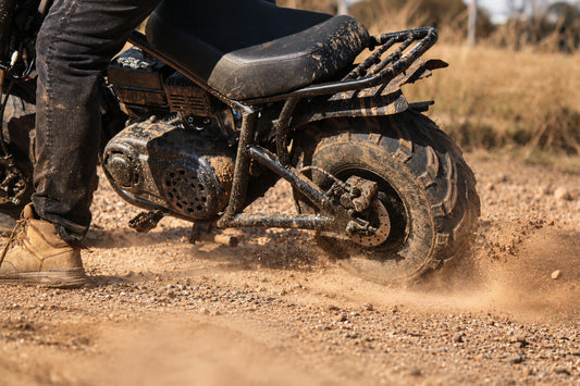 Close up of rear side of FatCat Mini Bike kicking up dust from back tyre on dirt track